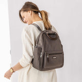 Woman Wearing Baggallini All Day Backpack with RFID Phone Wristlet